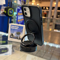 A smartphone featuring a black carbon fiber case and an attached metallic ring holder with an "ON OFF" dial is displayed on a clear counter, with a "Vacuum adsorption Magnetic support" product box and blurred retail environment in the background