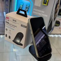A black MyBat Pro PowerPerch wireless charger stand holding an iPhone in a clear case, showcased on a retail display with vibrant blue LED lighting and a "Premium Protection" sign