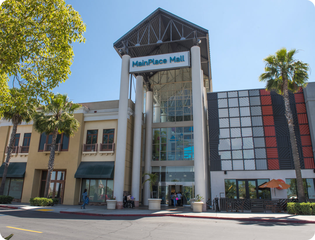 MainPlace Mall entrance with trees and clear sky